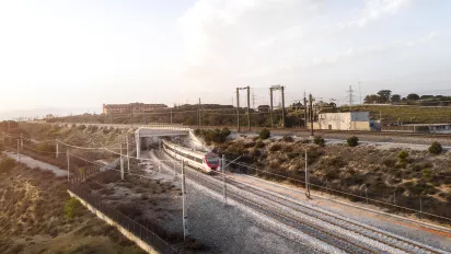 An aerial view of a train on rail tracks.